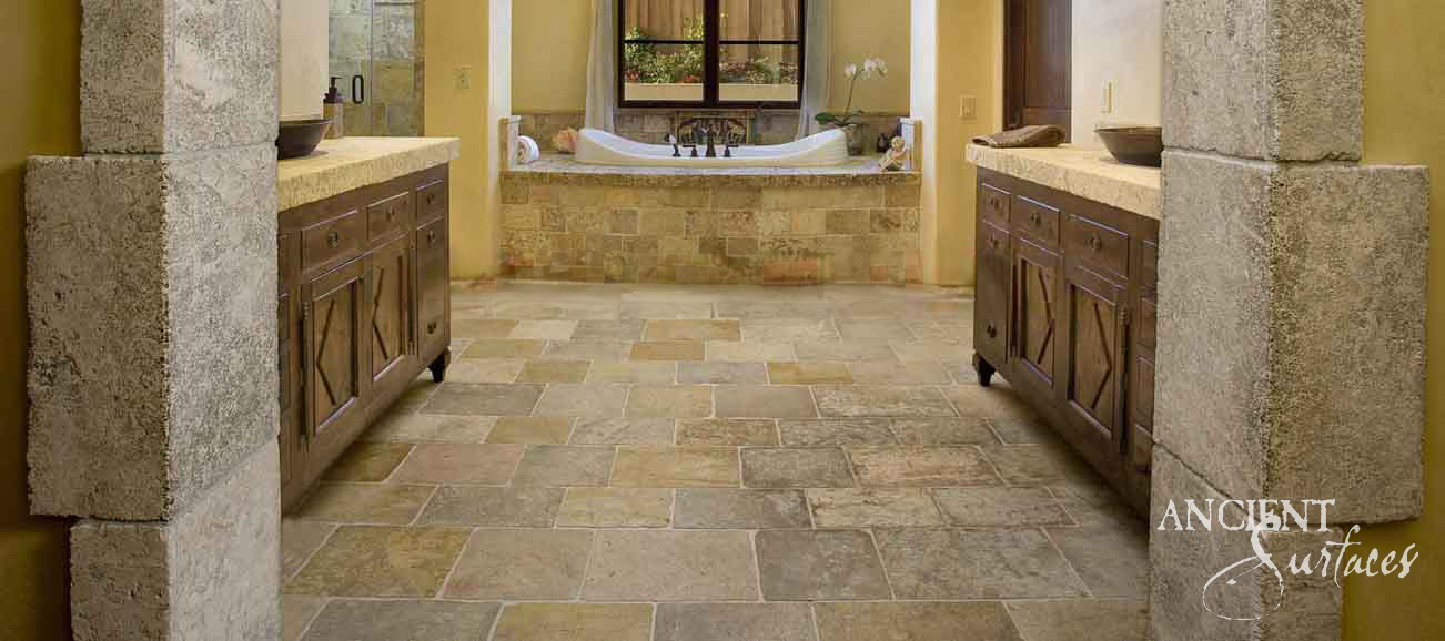 Reclaimed Arcane stone flooring laid through a stone framed bathroom