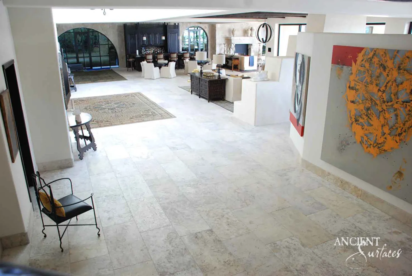 Reclaimed limestone plank flooring running through an open living space