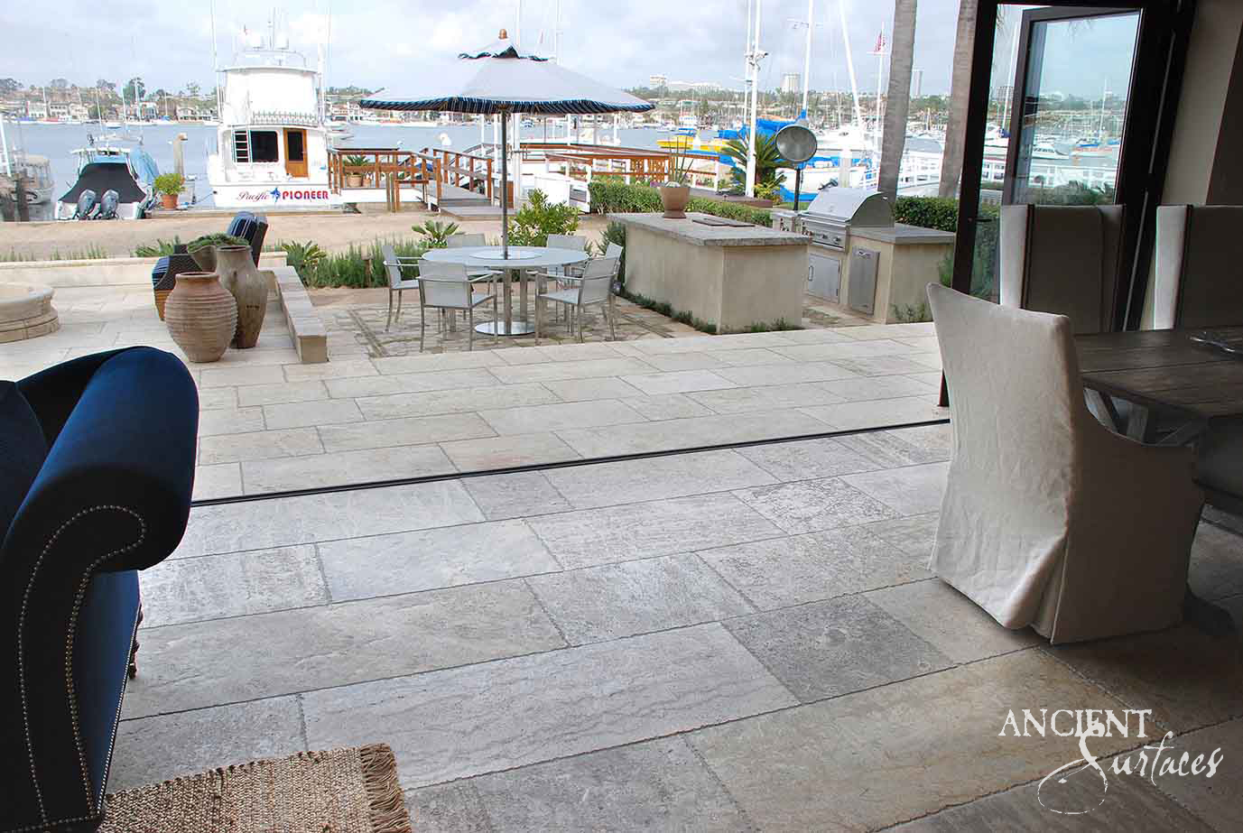 Reclaimed limestone plank flooring carried from an interior out to a waterfront terrace